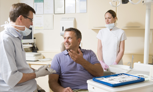 Man talking to dentist about dental crowns in Metairie