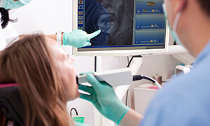 Dentist showing a patient their dental x rays using advanced dental technology in Metairie
