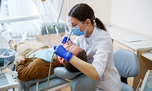  a dentist treating a patient’s tooth