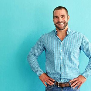 Man with veneers in Metairie smiling against teal background