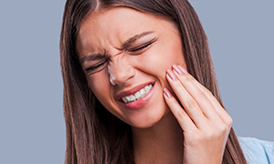 Young woman holding her jaw in pain