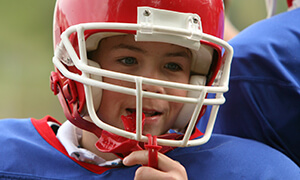 Football player wearing a red helmet and mouthguard