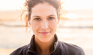 Woman with ponytail smiling outdoors