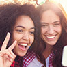 Two young women taking selfie together outdoors