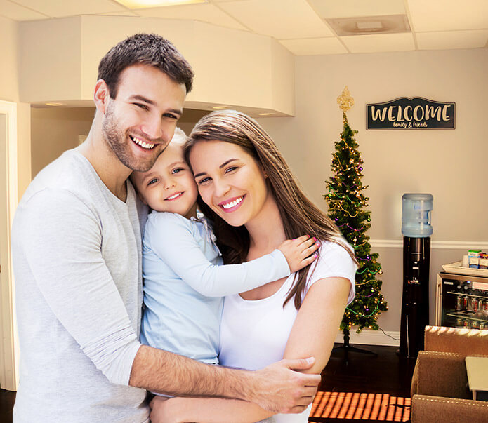 Smiling family of three in dental office