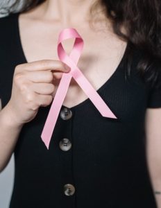 Woman holding pink breast cancer ribbon