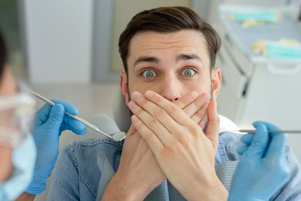 A man covering his mouth in fear